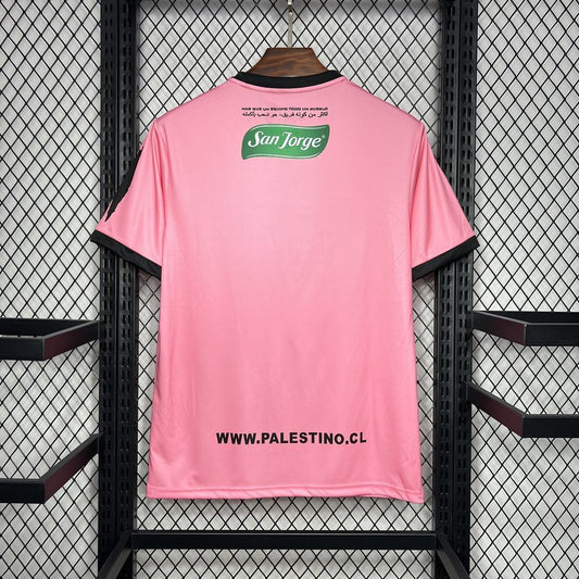 Maglia Palestina Pink Edition 2024/25 con grafica urbana, colori bandiera, e logo Bank of Palestine – streetwear politico-culturale
