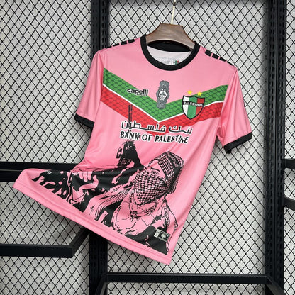 Maglia Palestina Pink Edition 2024/25 con grafica urbana, colori bandiera, e logo Bank of Palestine – streetwear politico-culturale
